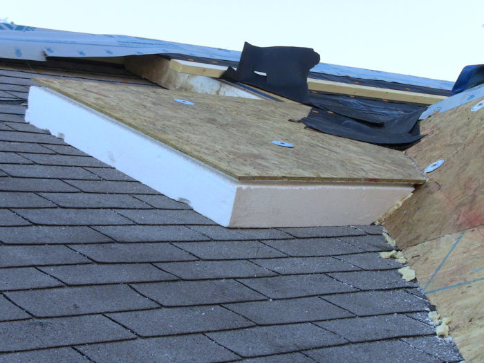 Construction photograph of exterior roof insulation and added roof-edge detail